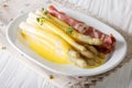 Organic fresh white asparagus with hollandaise sauce and ham close-up on a plate. horizontal Royalty Free Stock Photo