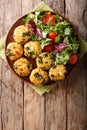 Organic fried meatballs with spinach and vegetable salad close-up. Vertical top view
