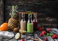 Organic fruit smoothies in glass bottles on wooden background Royalty Free Stock Photo