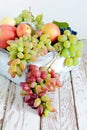 Organic fruits in a wooden crate. Bunches of ripe grapes and apples. Summer fruit