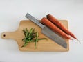 Organic green beans and carrots on a wooden chopping board and a knife . Cooking healthy vegetables Royalty Free Stock Photo