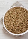 Organic green lentils in a white bowl on a white wooden background, top view. Close-up Royalty Free Stock Photo