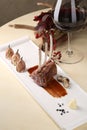 Organic Grilled Lamb Chops with Garlic and sauce on a white plate the background of glass red wine, flowers Royalty Free Stock Photo