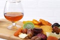 Organic Healthy Assorted Dried Fruit and glasses with cognac or whiskey on wine board. Selective focus. Royalty Free Stock Photo
