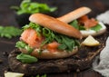 Organic healthy sandwiches with salmon and bagel, cream cheese and wild rocket and lemon
