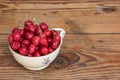 Organic homegrown cherries in a vintage ceramic bowl, on wooden background