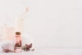 Organic homemade white cosmetics with pink flowers and massage oil on white wooden background, border. Royalty Free Stock Photo