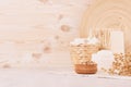 Organic homemade white cosmetics and raw oatmeal flakes, bath accessories on light beige wooden background, border. Royalty Free Stock Photo