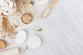 Organic homemade white cosmetics and raw oatmeal flakes, massage oil, bath accessories on light beige wooden background, flat lay. Royalty Free Stock Photo