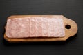 Organic Jamon Cocido Extra on a rustic wooden board on a black surface, low angle view