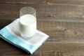 Organic kefir, ayran or milk poured into a glass cup stands on a cotton napkin on a wooden table. Source of Pribiotics. Place for