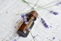 Organic lavender essential oil in dark glass bottle with fresh lavender flowers over vintage wooden background Royalty Free Stock Photo