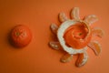 Organic mandarin wedges arranged in a circle with spiral peel and one whole mandarin on an orange paper background