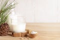 Organic milk replacer - cedar milk in glass, flour in wooden spoon for its cooking on wooden table.