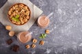 Organic non dairy walnut chocolate milk in glass and wooden plate with walnuts on a black concrete background