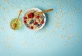 Organic oat flakes with blueberries and raspberries and honey over colorful background. Macro photo of natural raw food Royalty Free Stock Photo