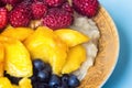 Organic oatmeal porridge in white ceramic bowl with raspberries, peaches and blueberries. Healthy breakfast - health and diet conc