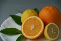 Organic orange and lemon on white plate with the gray background - Royalty Free Stock Photo