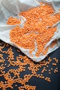 Organic orange lentils scattered on white paper and black background Royalty Free Stock Photo