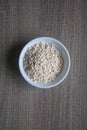 Organic Pearl barley in white ceramic bowl on wooden background Royalty Free Stock Photo