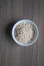 Organic Pearl barley in white ceramic bowl on wooden background Royalty Free Stock Photo