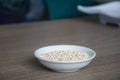 Organic Pearl barley in white ceramic bowl on wooden background Royalty Free Stock Photo