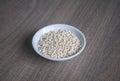 Organic Pearl barley in white ceramic bowl on wooden background Royalty Free Stock Photo