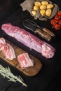 Organic pork fillet with ingredients and herbs for grill or baking, sage, potatoe, on black wooden table background Royalty Free Stock Photo