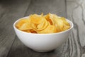 Organic potato chips in white bowl on wood table Royalty Free Stock Photo