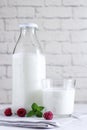 Organic probiotic milk kefir drink or yogurt in glass containers, with raspberry, on the white grey background. Gut health.