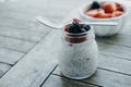 Organic Pudding with chia seeds and spoon, yogurt and fresh fruits: Strawberries, blueberries and blackberries in glass jars on w