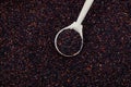 Organic ragi or black quinoa in wooden spoon, top view. Natural cereal background, selective focus, copy space