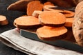 Organic raw sweet potato whole and sliced on wooden kitchen board. Rustic style Royalty Free Stock Photo