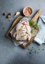 organic raw whole chicken with thyme peppers and garlic on a rustic table Royalty Free Stock Photo