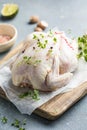 organic raw whole chicken with thyme peppers and garlic on a rustic table Royalty Free Stock Photo