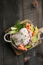 organic raw whole chicken with thyme peppers and garlic on a rustic table Royalty Free Stock Photo