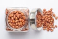 Organic red brown peanuts Arachis hypogaea in a glass jar with Lid