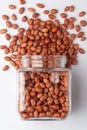 Organic red-brown peanuts Arachis hypogaea,  spilled and in a glass jar, Royalty Free Stock Photo