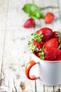 Organic red strawberries in white ceramic cup on rustic wooden background Royalty Free Stock Photo