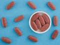 Organic red yeast rice tablets in a cap with other organic red yeast rice tablets around them Royalty Free Stock Photo