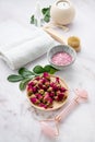 Organic sea salt for the body with dried rose flowers, candle, brush, towel and gua sha on a pink marble background. The concept Royalty Free Stock Photo