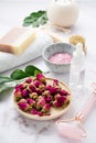 Organic sea salt for the body with dried rose flowers, candle, brush, towel and gua sha on a pink marble background close up. The Royalty Free Stock Photo