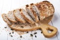 Organic seed bread. Sourdough bread. Bread cut in slices on a white wood background