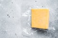 Organic Sharp Cheddar Cheese in vacuum packaging. Gray background. Top view. Copy space