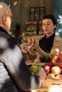 Organic shop owner showing bunch of carrots to customer Royalty Free Stock Photo