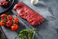 Organic tri tip, triangle  roast cut steak on black  slate raw meat , marbled beef over other alternative cuts  with herbs Royalty Free Stock Photo
