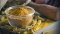 Organic Turmeric dried pieces and powder in glass bowl on old wooden table.