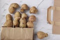 Organic ugly potatoes in a paper bag on a marble background, organic vegetables concept, Zero waste concept, Closeup