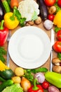 Organic Vegetables Around White Plate with Knife and Fork Royalty Free Stock Photo