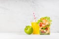 Organic vitamin meal take away - lunch set of orange juice, green apple, fresh sea food salad with shrimps, lettuce, red pepper. Royalty Free Stock Photo